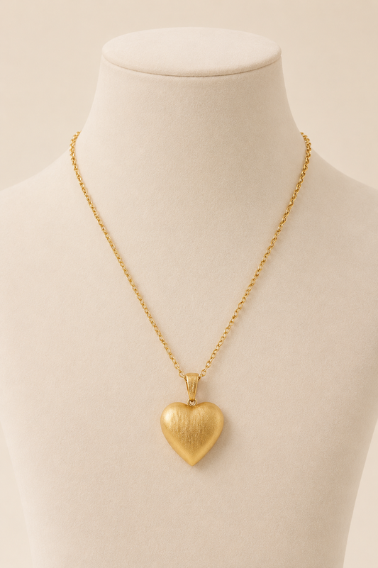 Amora textured gold heart pendant necklace displayed on cream mannequin