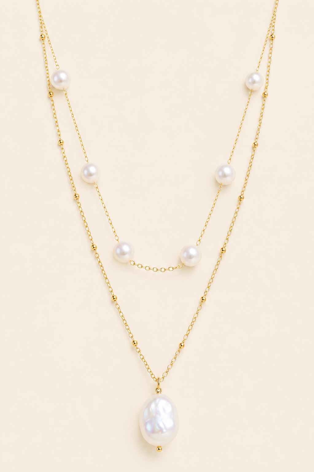 Aurelia baroque pearl layered gold necklace with two chains and white pearl accents on soft ivory cream background