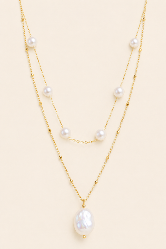 Aurelia baroque pearl layered gold necklace with two chains and white pearl accents on soft ivory cream background