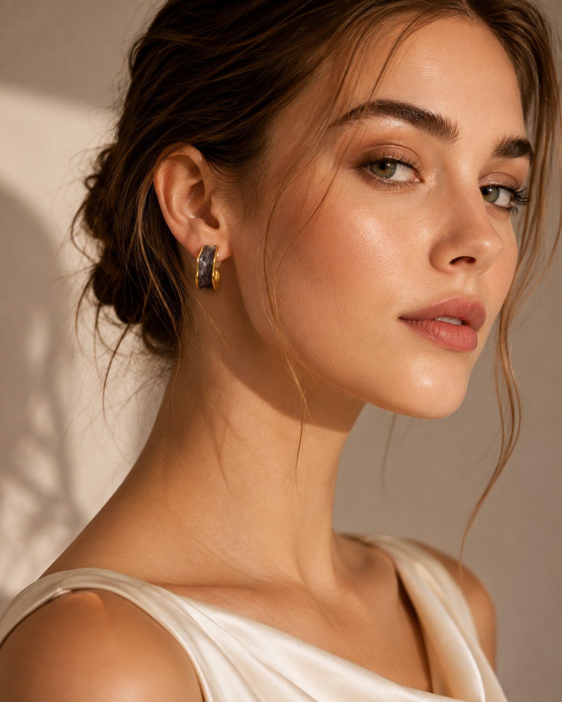 Model wearing brown marbled gold-tone sculpted hoop earrings