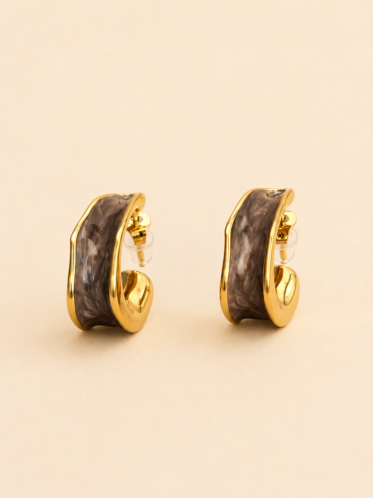 Brown marbled gold-tone sculpted hoop earrings on soft ivory cream background