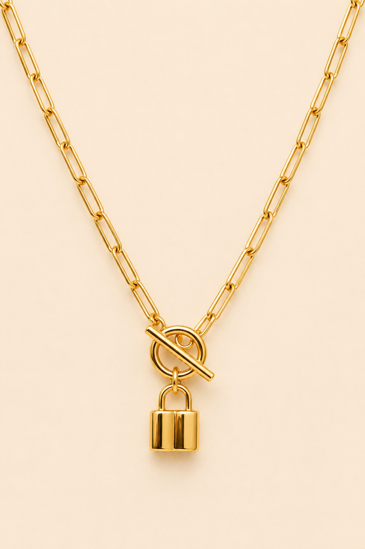 Close-up of Éclat Lock gold toggle necklace and padlock pendant