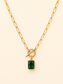 A gold paperclip chain necklace with a toggle clasp and a rectangular emerald-cut green gemstone pendant, displayed on a light cream background.