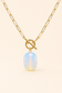 Gold chain necklace with a toggle clasp and a smooth, oval-shaped iridescent opal pendant, displayed on a light cream background.