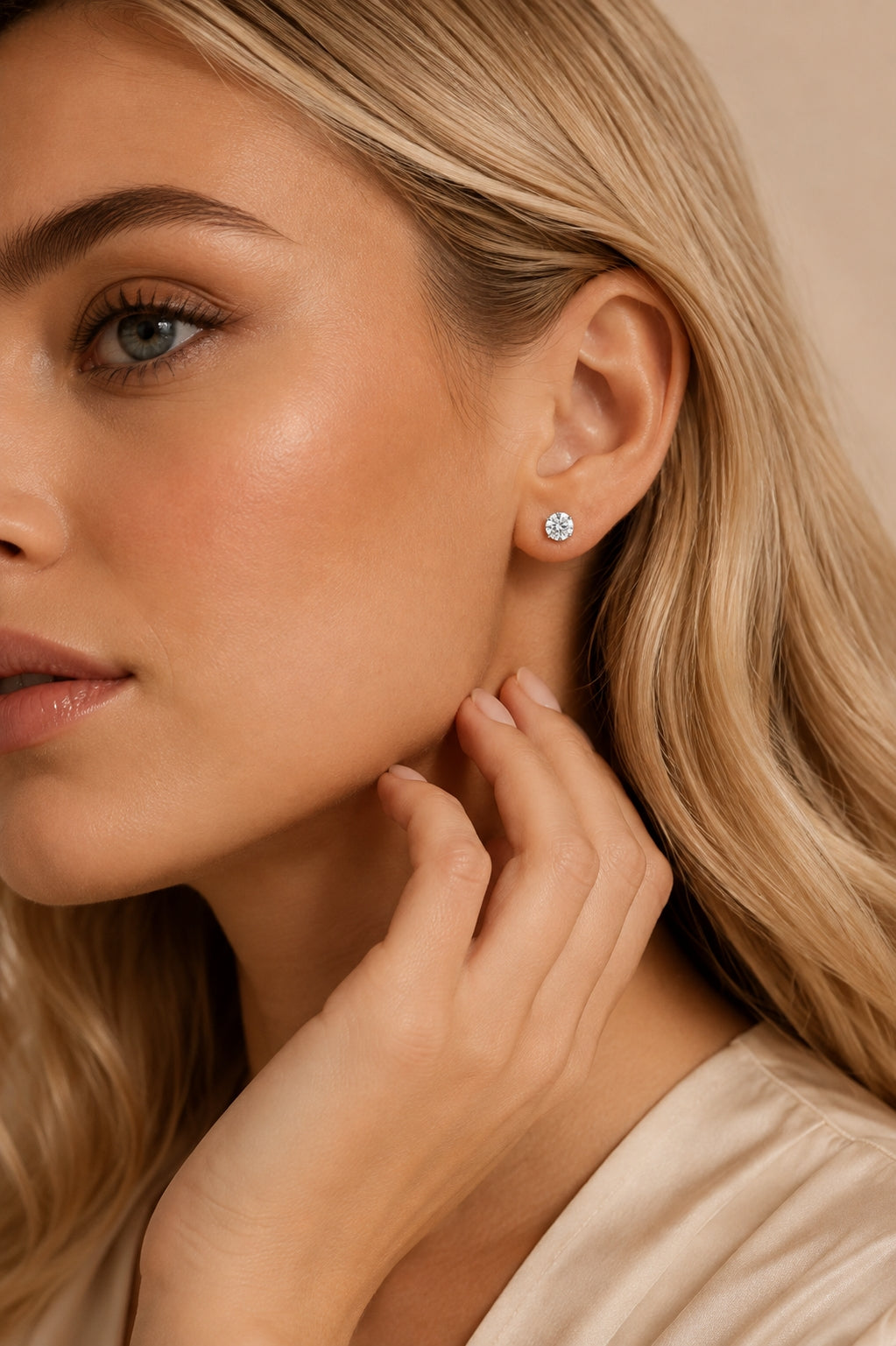 Model wearing round solitaire crystal stud earrings in a close-up jewellery look.