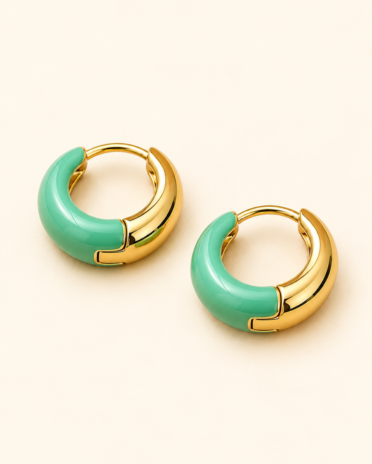 Sage Arc 18K gold-plated huggie hoop earrings with sage green enamel on a Soft Ivory Cream background.