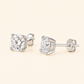 A pair of round-cut diamond stud earrings in a silver four-prong setting, shown from both front and side angles on a light cream background.