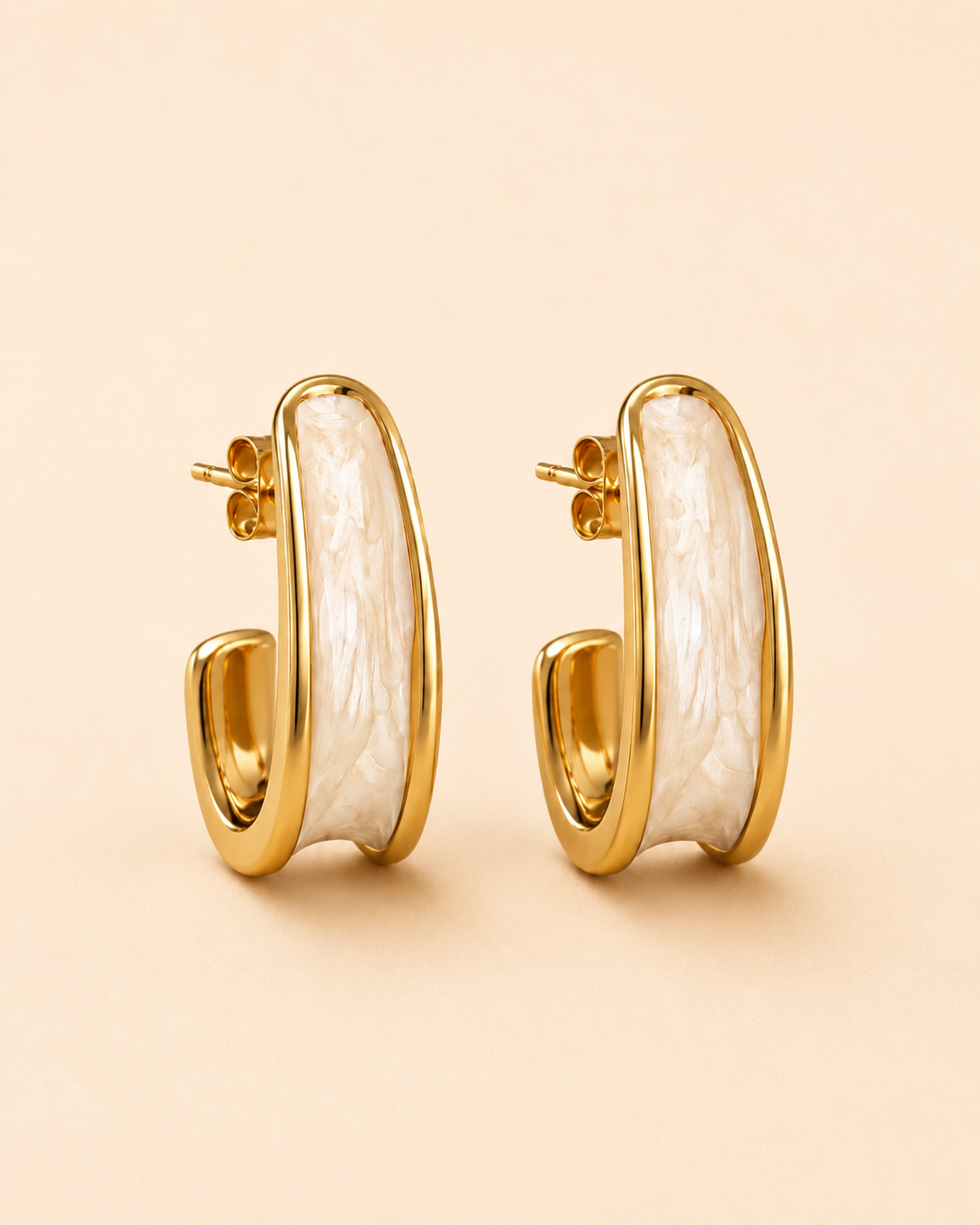 Ivory marble and gold sculpted hoop earrings on soft ivory cream background.