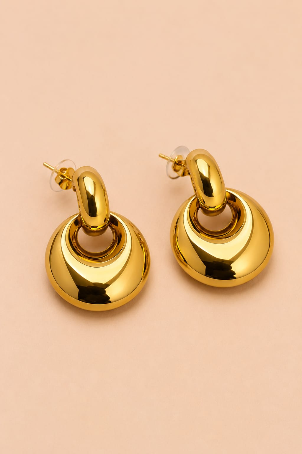 Three-quarter view of Valoria London Aurelia polished gold statement earrings with sculptural drop design