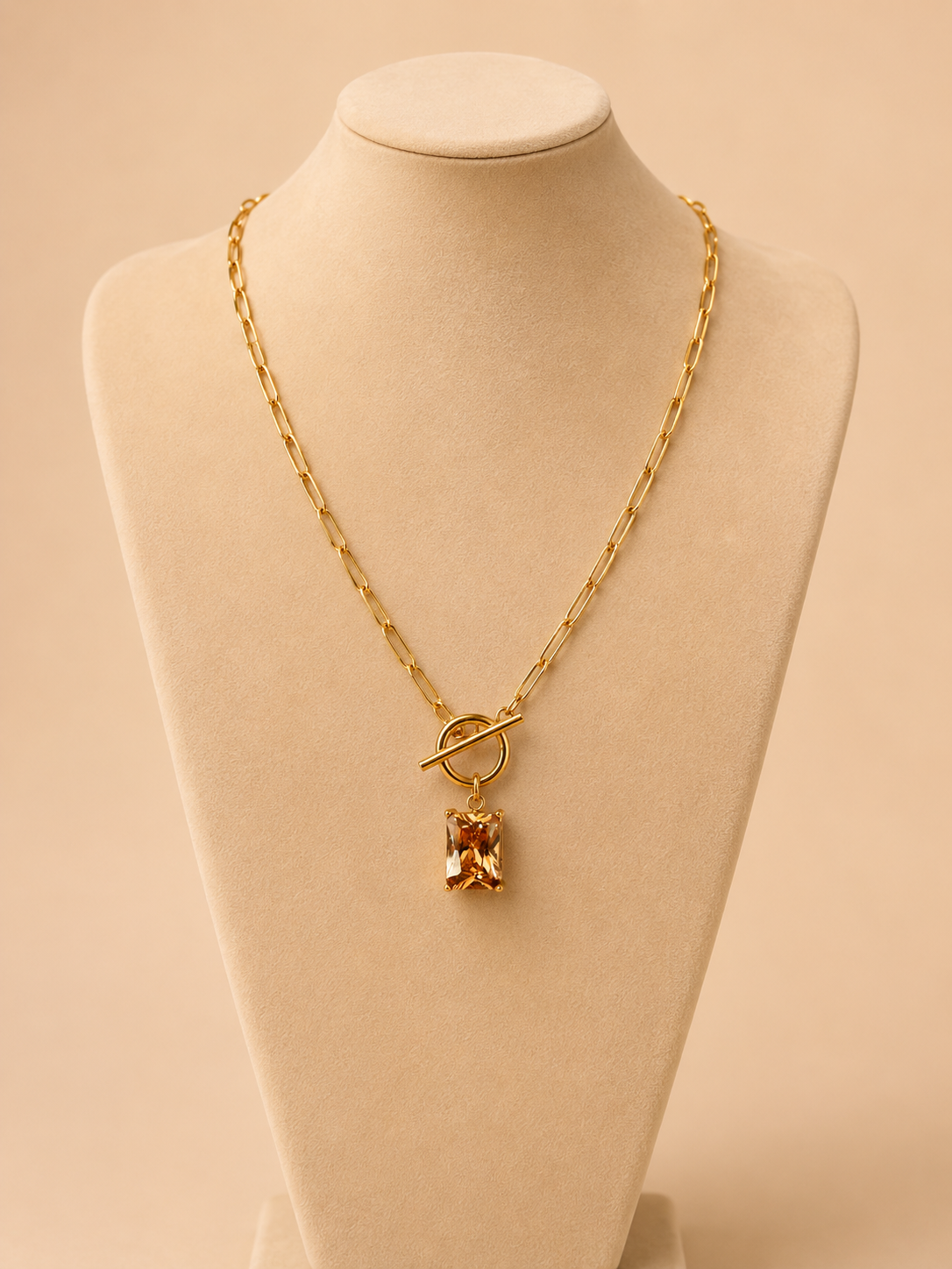 Valoria London gold paperclip chain necklace with toggle clasp and rectangular champagne crystal pendant displayed on a jewellery bust