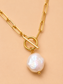 Close-up of the Valoria London Elara gold paperclip chain necklace with toggle detail and irregular pearl-effect pendant