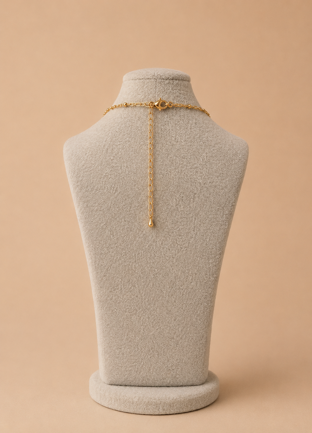 Back view of gold paperclip necklace with lobster clasp and extender chain on a cream mannequin