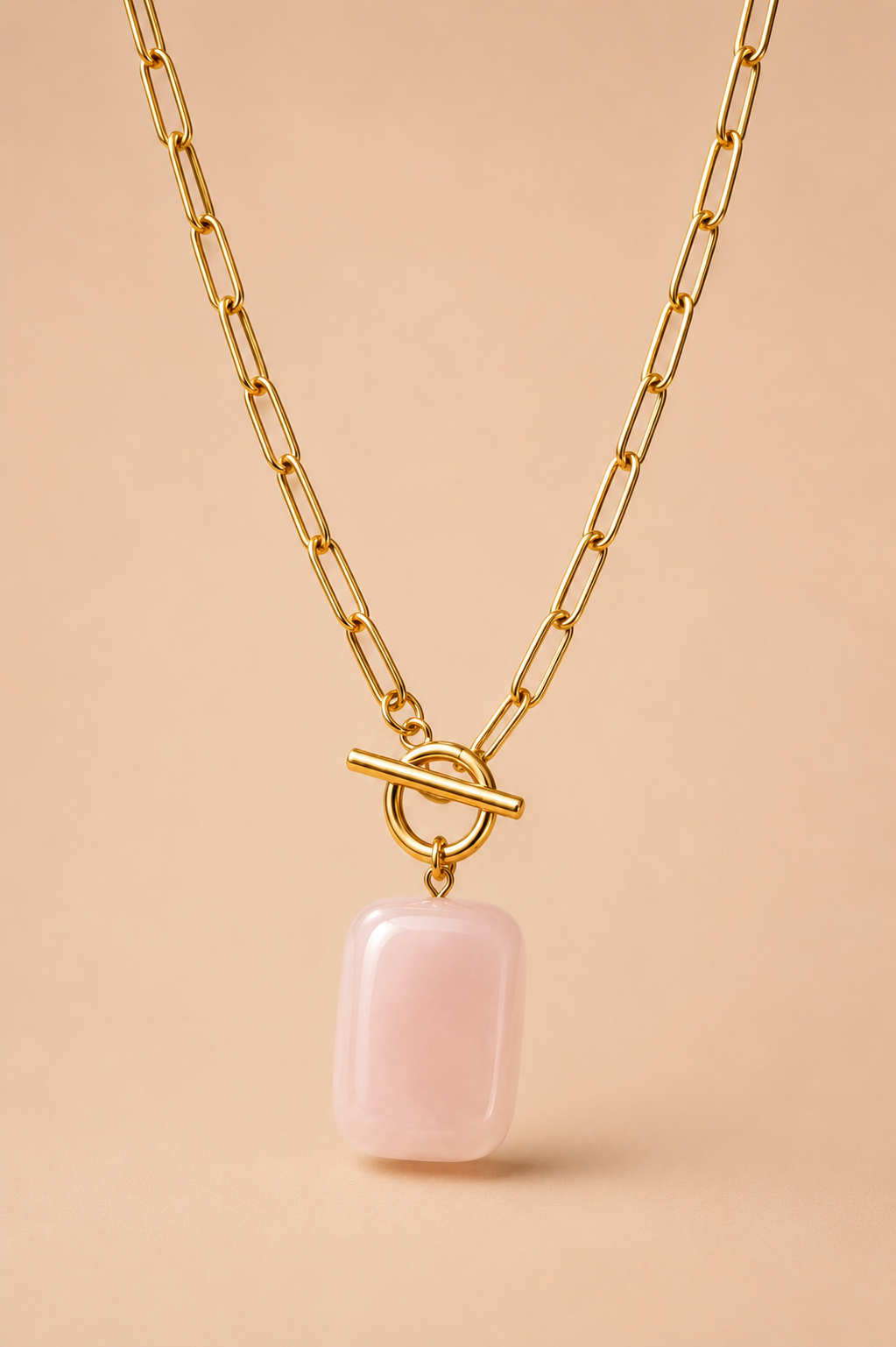 Valoria London gold paperclip chain necklace with toggle clasp and pink rectangular stone pendant, front view on jewellery display