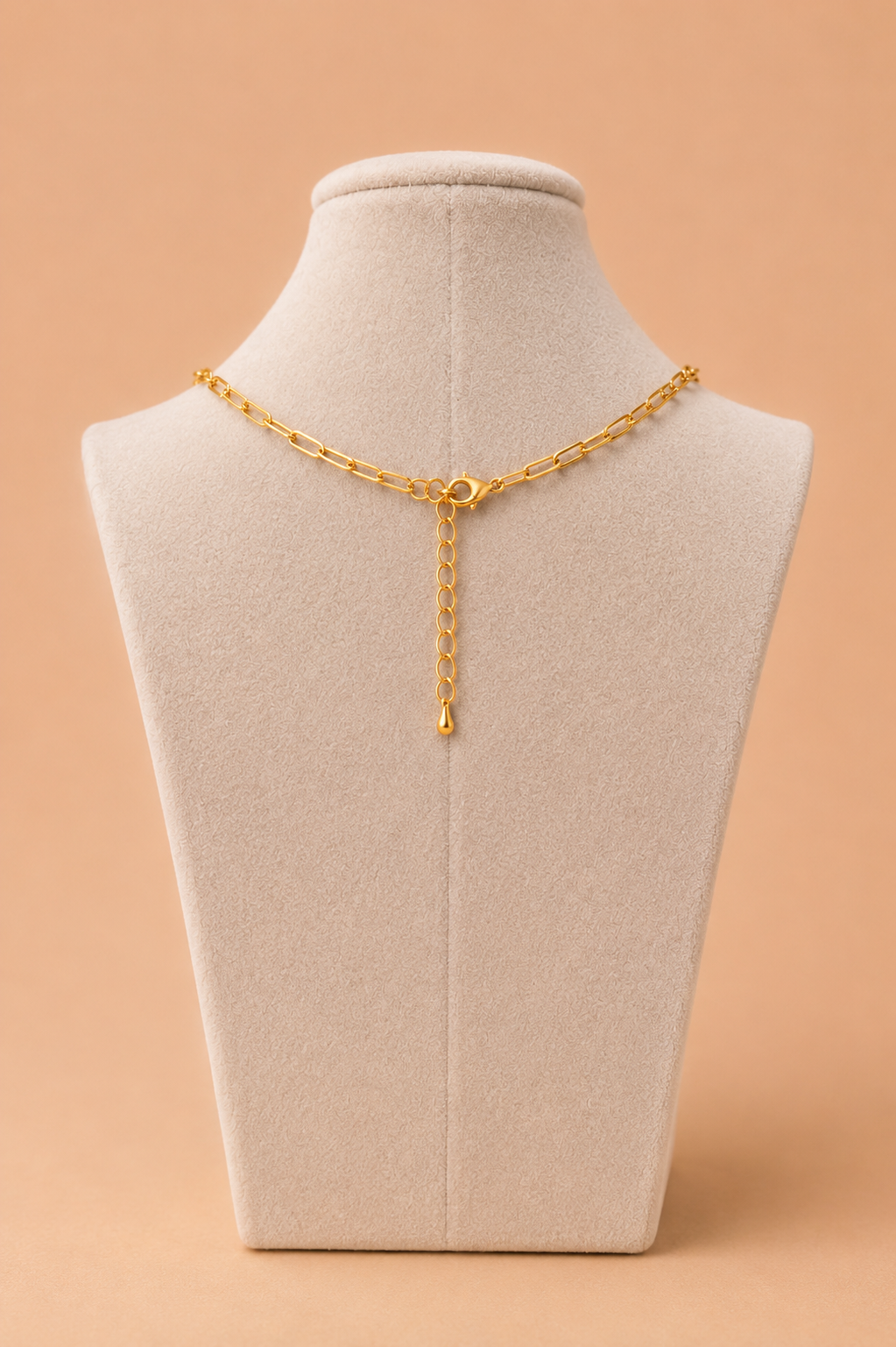 Back view of gold paperclip necklace with lobster clasp and extender chain on a cream mannequin